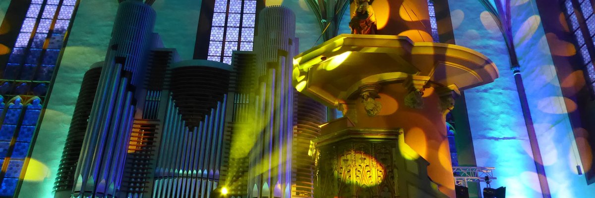 Орган със зелена, синя и жълта илюминация в готическа църква